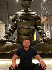 Tyler Workman sitting in front of a statue